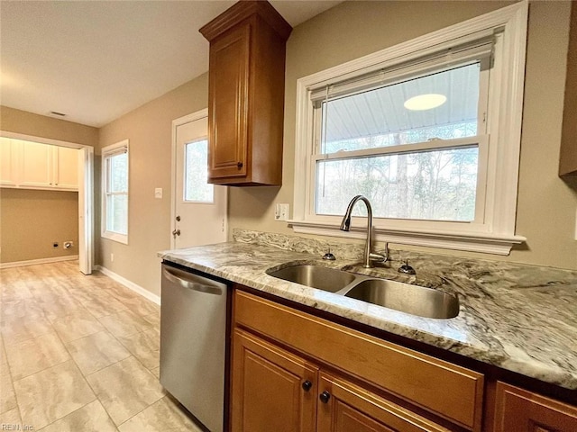 10104 Ogilvy Ln, Carrollton, VA 23314 - kitchen with stainless steel dishwasher, a sink, brown cabinetry, and light stone counters
