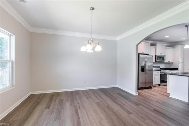 429 Draper Dr, Norfolk, VA 23505 - unfurnished dining area with wood finished floors, crown molding, arched walkways, baseboards, and a chandelier