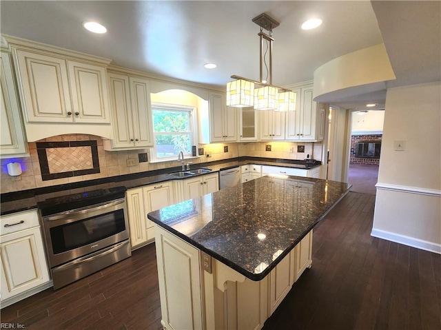 5097 Rochelle Rd, Virginia Beach, VA 23464 - kitchen with cream cabinets, appliances with stainless steel finishes, a sink, dark wood-style flooring, and backsplash