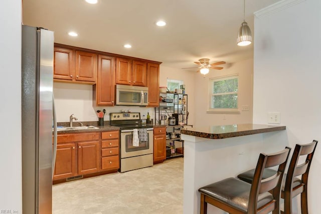 1621 Bill St, Norfolk, VA 23518 - kitchen with appliances with stainless steel finishes, a sink, a kitchen bar, a ceiling fan, and brown cabinets