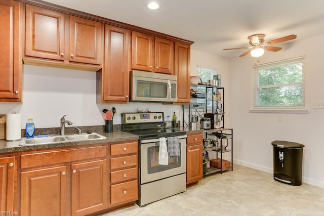 1621 Bill St, Norfolk, VA 23518 - kitchen with appliances with stainless steel finishes, a sink, dark countertops, ceiling fan, and brown cabinetry