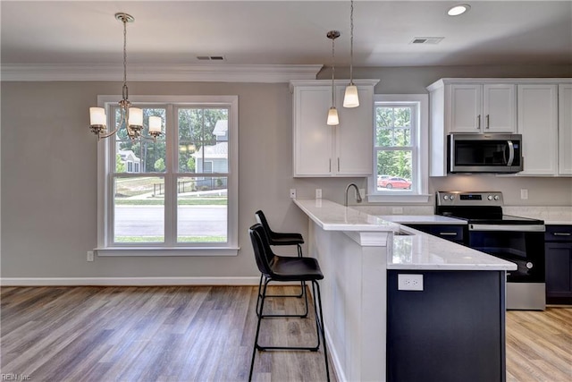 3545 Amberley Way, Williamsburg, VA 23188 - kitchen featuring appliances with stainless steel finishes, white cabinetry, a kitchen breakfast bar, light wood-style flooring, and ornamental molding