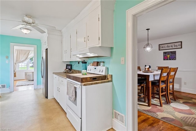 108 Pocahontas St, Franklin, VA 23851 - kitchen with under cabinet range hood, white electric range oven, freestanding refrigerator, and white cabinetry