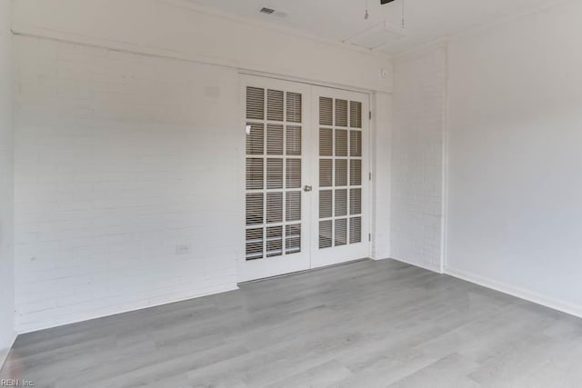 722 White Hall Ln, Virginia Beach, VA 23464 - empty room with wood finished floors, brick wall, french doors, and baseboards