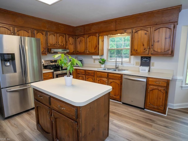 3124 Douglas Rd, Chesapeake, VA 23322 - kitchen with stainless steel appliances, a sink, under cabinet range hood, light wood finished floors, and brown cabinetry