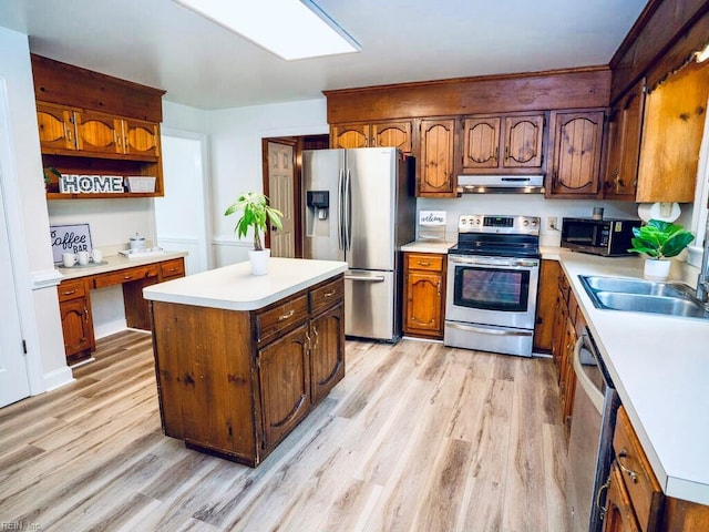 3124 Douglas Rd, Chesapeake, VA 23322 - kitchen featuring stainless steel appliances, a sink, light wood-style flooring, under cabinet range hood, and a kitchen island