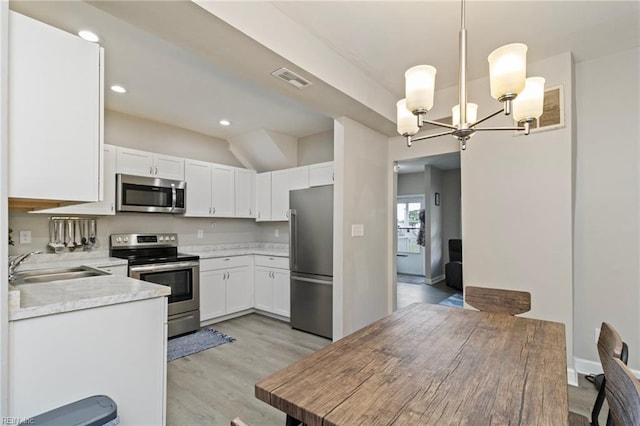4 Hopkins St, Hampton, VA 23663 - kitchen with appliances with stainless steel finishes, a sink, a chandelier, light wood-style flooring, and light countertops