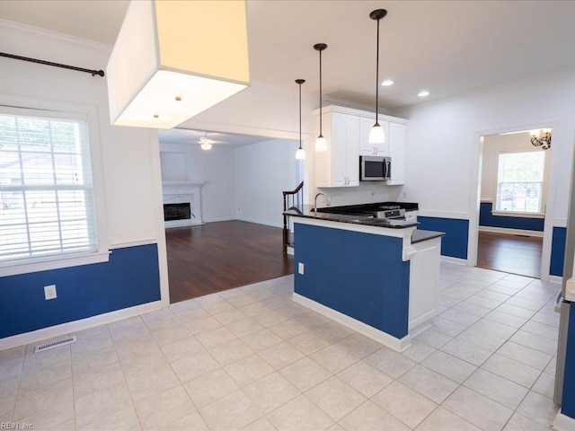 4604 Bellamy Ct, Virginia Beach, VA 23462 - kitchen featuring stainless steel microwave, dark countertops, ceiling fan, white cabinetry, and open floor plan