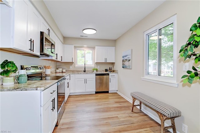 166 Mill Point Dr, Hampton, VA 23669 - kitchen with stainless steel appliances, light wood finished floors, white cabinets, light stone countertops, and baseboards