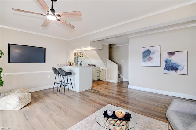 166 Mill Point Dr, Hampton, VA 23669 - living area featuring light wood finished floors, stairs, bar with sink, ceiling fan, and baseboards