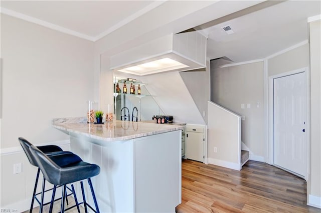 166 Mill Point Dr, Hampton, VA 23669 - kitchen featuring a breakfast bar, light wood-type flooring, ornamental molding, white cabinets, and a peninsula