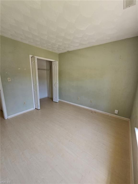 834 Haskins Dr, Suffolk, VA 23434 - unfurnished bedroom with baseboards, a closet, and light wood finished floors