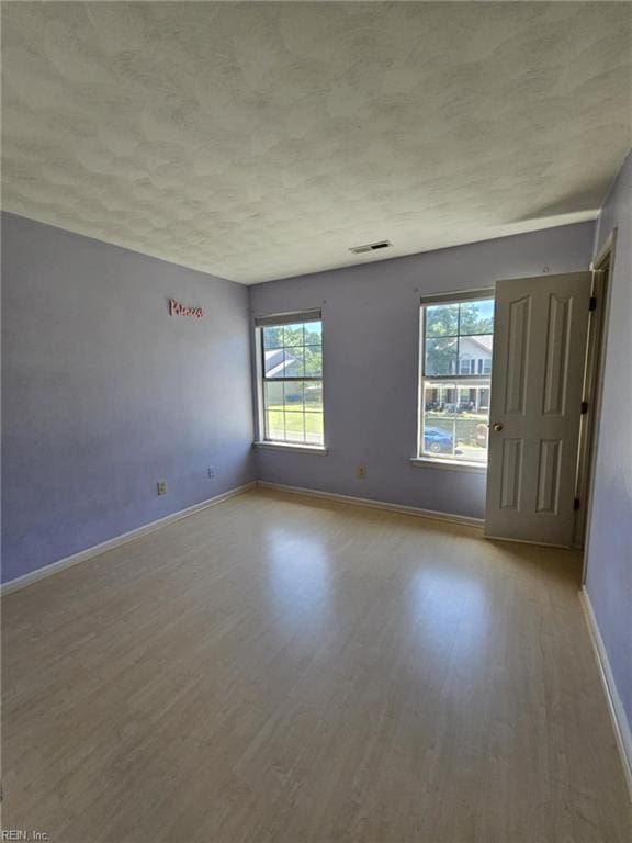 834 Haskins Dr, Suffolk, VA 23434 - spare room with wood finished floors, healthy amount of natural light, baseboards, and a textured ceiling