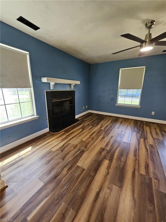 834 Haskins Dr, Suffolk, VA 23434 - unfurnished living room featuring plenty of natural light, wood finished floors, a fireplace with flush hearth, and ceiling fan