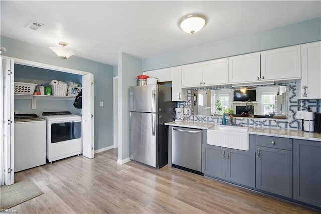 1765 Unicorn Dr, Virginia Beach, VA 23454 - kitchen with appliances with stainless steel finishes, washer and clothes dryer, a sink, and white cabinetry