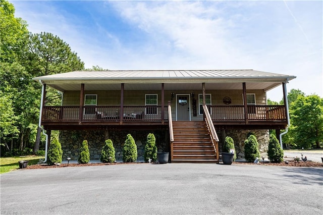 14387 Tucker Swamp Rd, Zuni, VA 23898 - view of front of home featuring stone siding, covered porch, stairs, a standing seam roof, and metal roof