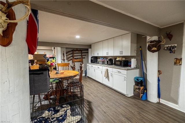 14387 Tucker Swamp Rd, Zuni, VA 23898 - kitchen featuring white cabinets, wood finished floors, black microwave, baseboards, and ornamental molding
