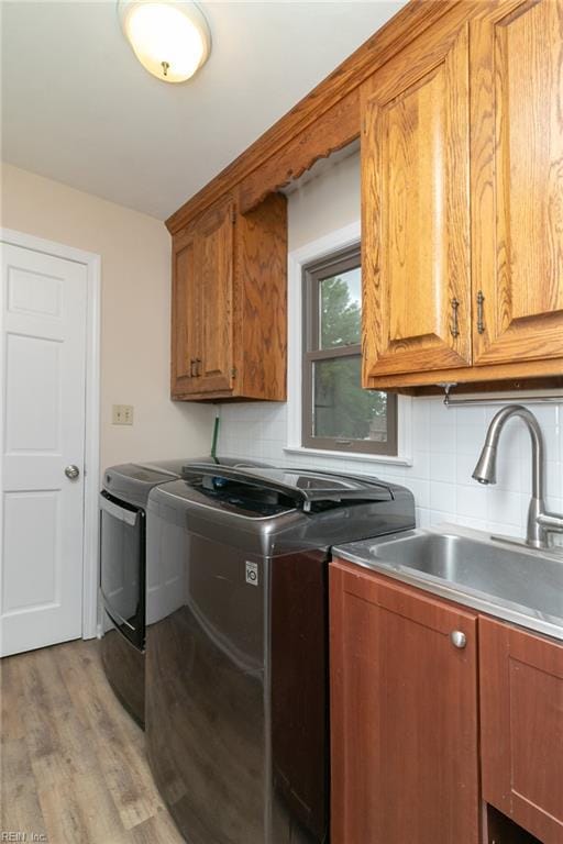 1238 Grenadier Dr, Chesapeake, VA 23322 - laundry room featuring washing machine and clothes dryer, cabinet space, and light wood finished floors