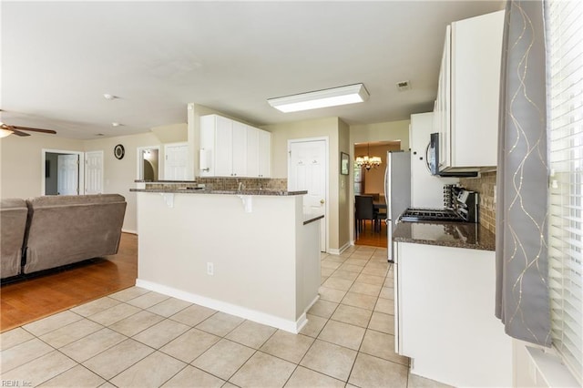 115 Rochdale Ln, Suffolk, VA 23434 - kitchen featuring light tile patterned floors, open floor plan, a kitchen bar, decorative backsplash, and white cabinetry