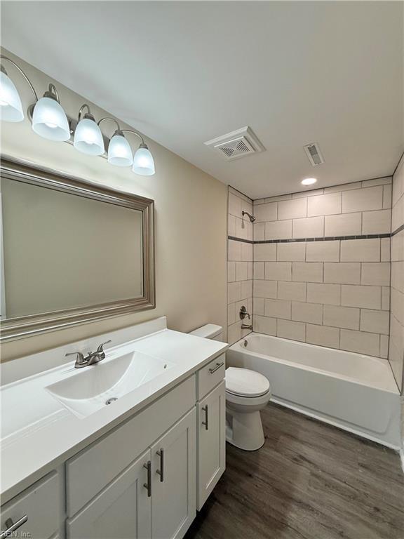 2218 Andrews Blvd, Hampton, VA 23663 - bathroom with vanity, toilet, wood finished floors, and bathtub / shower combination