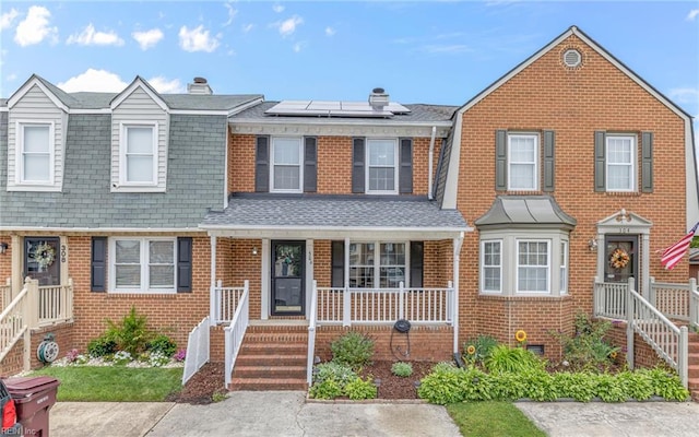 306 San Roman Dr, Chesapeake, VA 23322 - view of property with brick siding, a porch, solar panels, and a shingled roof