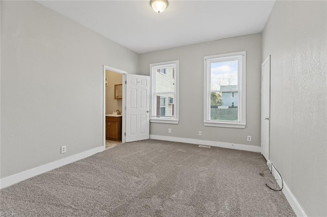 3120 Tidewater Dr, Norfolk, VA 23509 - unfurnished bedroom featuring carpet, baseboards, and connected bathroom