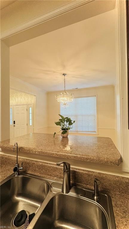 1107 Halton Ln, Chesapeake, VA 23320 - kitchen view of a sink, a chandelier, crown molding, hanging light fixtures, and stone counters