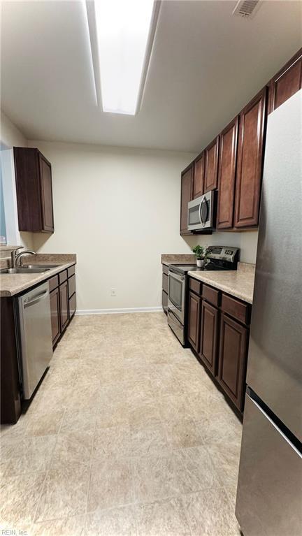 1107 Halton Ln, Chesapeake, VA 23320 - kitchen featuring appliances with stainless steel finishes, a sink, light countertops, and dark brown cabinetry