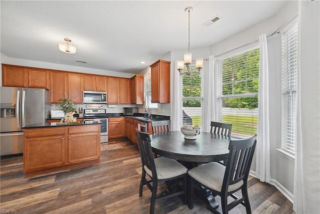 5520 White Swallow Way, Chesapeake, VA 23321 - kitchen with appliances with stainless steel finishes, dark countertops, dark wood finished floors, a chandelier, and brown cabinets