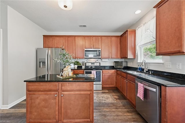 5520 White Swallow Way, Chesapeake, VA 23321 - kitchen featuring stainless steel appliances, a sink, dark wood finished floors, a center island, and dark stone counters