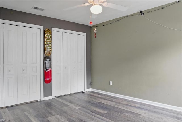 6412 Dove St, Norfolk, VA 23513 - unfurnished bedroom featuring multiple closets, wood finished floors, baseboards, and a ceiling fan