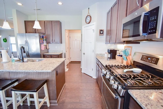 205 Markham St, Suffolk, VA 23435 - kitchen featuring stainless steel appliances, a sink, a kitchen breakfast bar, hanging light fixtures, and light stone counters