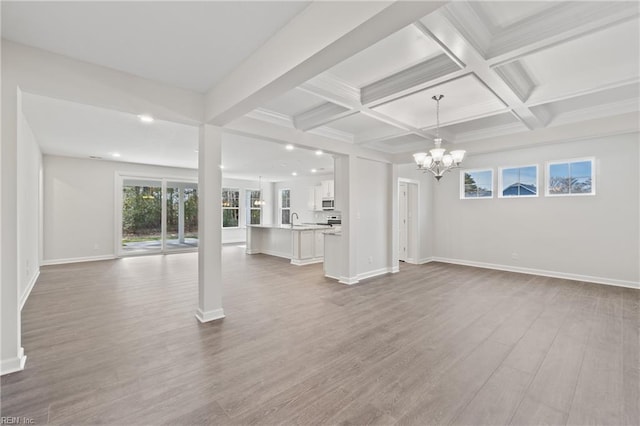 143 Highland Pony Dr, Hertford, NC 27944 - unfurnished living room featuring a chandelier, healthy amount of natural light, beam ceiling, wood finished floors, and a sink