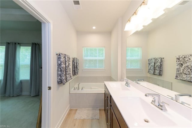 123 Big Woods Dr, Poquoson, VA 23662 - full bathroom with a garden tub, double vanity, wood finished floors, and baseboards