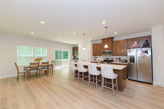 123 Big Woods Dr, Poquoson, VA 23662 - kitchen with stainless steel appliances, a kitchen island with sink, light countertops, light wood-style flooring, and recessed lighting