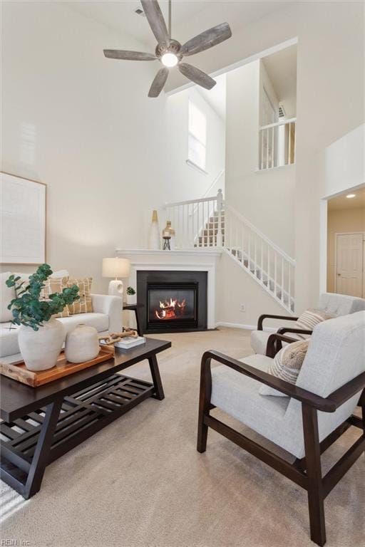 408 Holmes Blvd, Yorktown, VA 23692 - living area with a high ceiling, carpet floors, stairs, a glass covered fireplace, and ceiling fan
