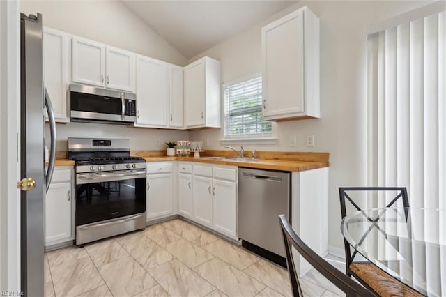 408 Holmes Blvd, Yorktown, VA 23692 - kitchen with stainless steel appliances, lofted ceiling, a sink, white cabinetry, and butcher block countertops
