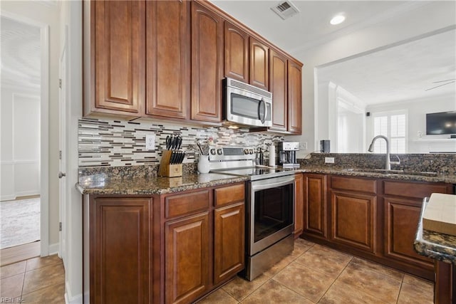 1200 Althea Ct, Chesapeake, VA 23322 - kitchen with appliances with stainless steel finishes, crown molding, dark stone counters, backsplash, and tile patterned floors