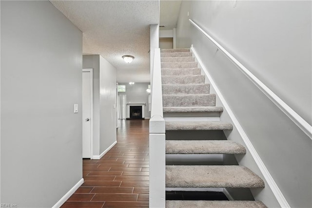 5101 Glenwood Way, Virginia Beach, VA 23456 - stairway with a textured ceiling, wood tiled floors, baseboards, and a fireplace