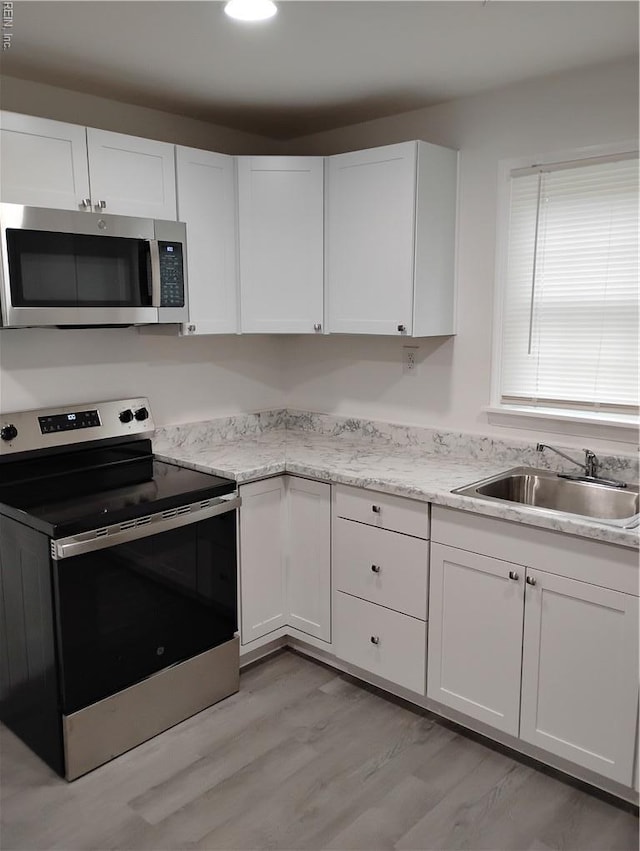 624 Crystal Ave, Chesapeake, VA 23324 - kitchen with appliances with stainless steel finishes, a sink, white cabinets, and light wood finished floors