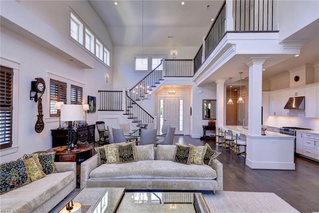 103 Enclave Ct, Williamsburg, VA 23185 - living room with a high ceiling, dark wood finished floors, stairs, and decorative columns