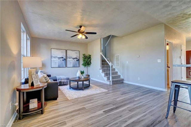 100 Langston Ct, Franklin, VA 23851 - living area with stairway, wood finished floors, a ceiling fan, and baseboards