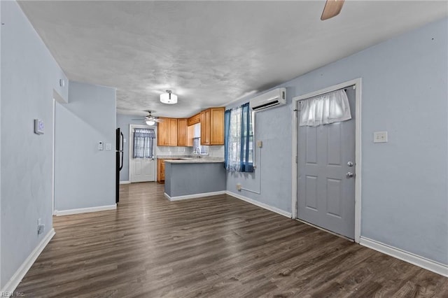 3505 Commonwealth Ave, Portsmouth, VA 23707 - kitchen with a ceiling fan, an AC wall unit, dark wood finished floors, light countertops, and baseboards