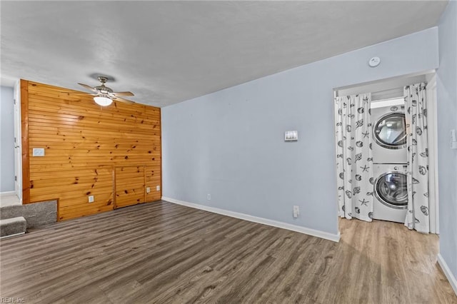 3505 Commonwealth Ave, Portsmouth, VA 23707 - unfurnished living room featuring stacked washer and clothes dryer, wood finished floors, ceiling fan, baseboards, and wooden walls