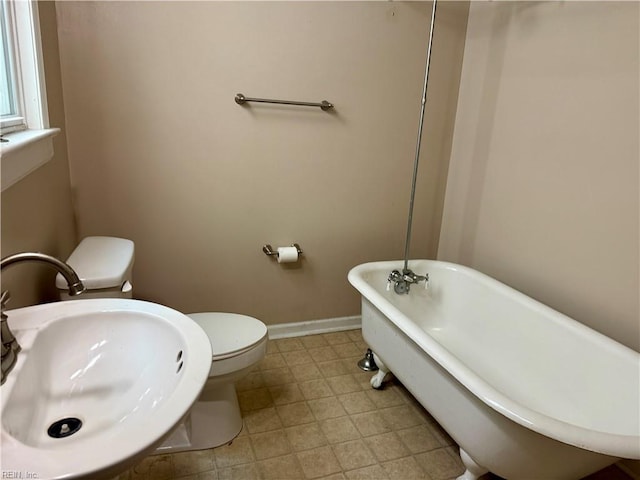 307 W 30th St, Norfolk, VA 23508 - bathroom featuring a freestanding tub, a sink, toilet, and baseboards