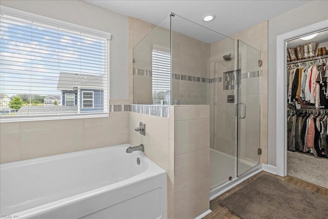 3012 George Starr Dr, Virginia Beach, VA 23456 - bathroom with plenty of natural light, a bath, a stall shower, a spacious closet, and a textured ceiling