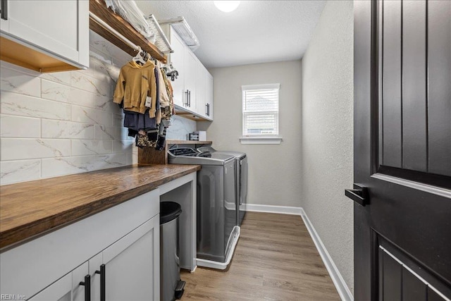3012 George Starr Dr, Virginia Beach, VA 23456 - washroom featuring washer and clothes dryer, cabinet space, light wood-style floors, baseboards, and a textured wall