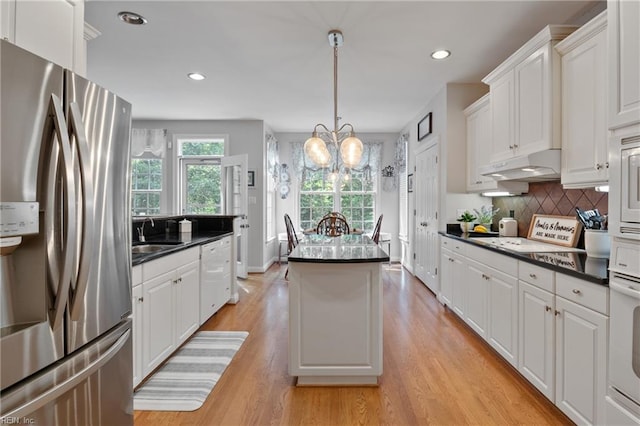 20185 Harbour Rdg, Smithfield, VA 23430 - kitchen with white appliances, under cabinet range hood, a sink, dark countertops, and a kitchen island