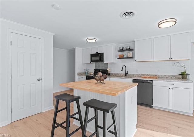 1215 Hale Dr, Hampton, VA 23663 - kitchen featuring black appliances, a sink, light wood-type flooring, a kitchen breakfast bar, and tasteful backsplash