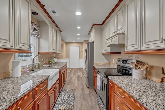 506 Everett Dr, Elizabeth City, NC 27909 - kitchen with stainless steel appliances, a sink, light wood-style flooring, custom range hood, and light stone counters